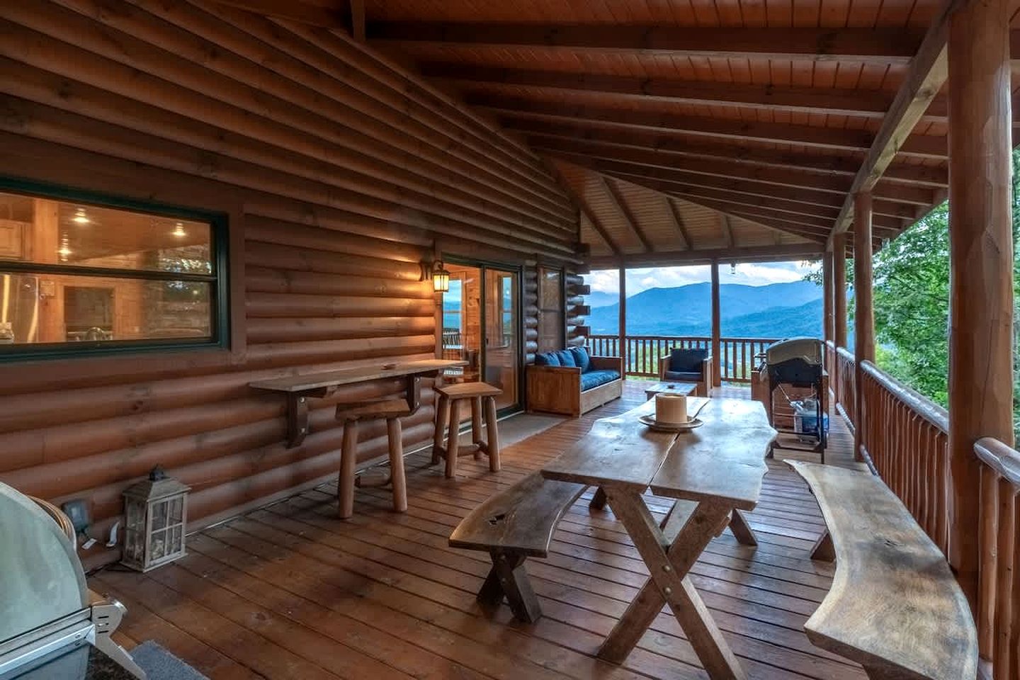 Eine Holzhütte mit überdachter Veranda, Holztischen und -bänken.