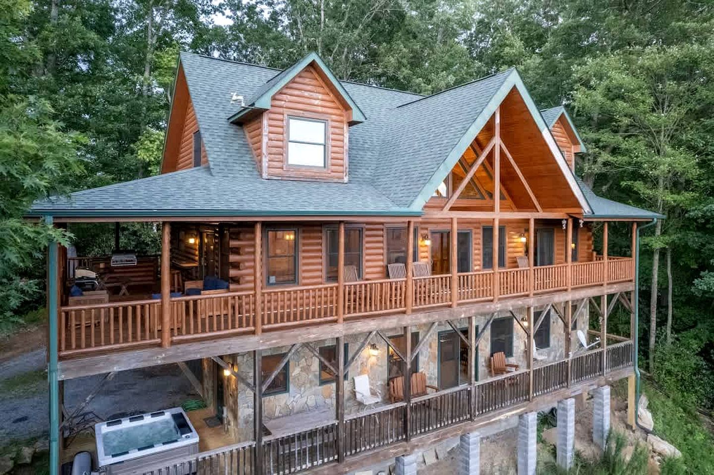A log cabin with a balcony and a hot tub.