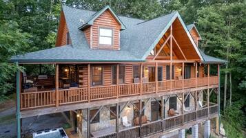 A log cabin with a balcony and a hot tub.