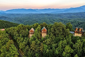 A forested mountain area with three cabins. - Extraordinary Smoky Mountain Cabin with Panoramic Views, Hot Tub & Arcade near Pigeon Forge and Gatlinburg, TN (Sevierville)