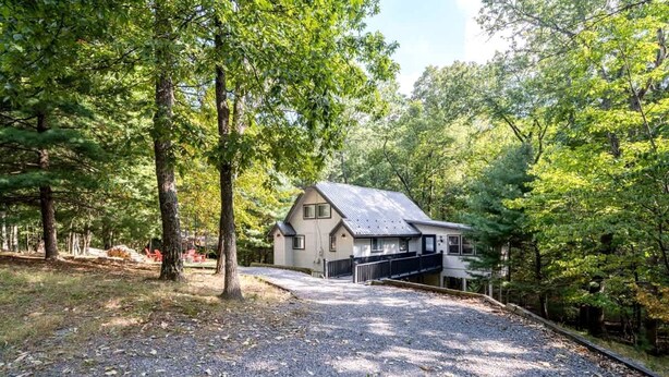 A house surrounded by trees with a gravel driveway. - Spacious Cabin with Fire Pit, Arcade Games, and Resort Access, the Perfect Base for Outdoor Adventures in Hedgesville, West Virginia (Hedgesville)