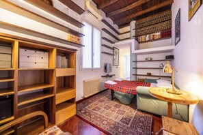 Une pièce confortable avec un lit, un bureau, une chaise, une bibliothèque et un radiateur.