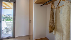 Une pièce dotée d’une porte-fenêtre coulissante donnant sur un balcon, d’un plafond en bois et d’une étagère murale sur laquelle est posé un article tricoté.