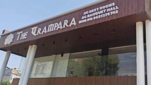 A building with a sign reading 'The Qrampera' and mentions 'AC RESTROOMS' and 'AC BANQUET HALL.' - The Parampara (Varanasi)