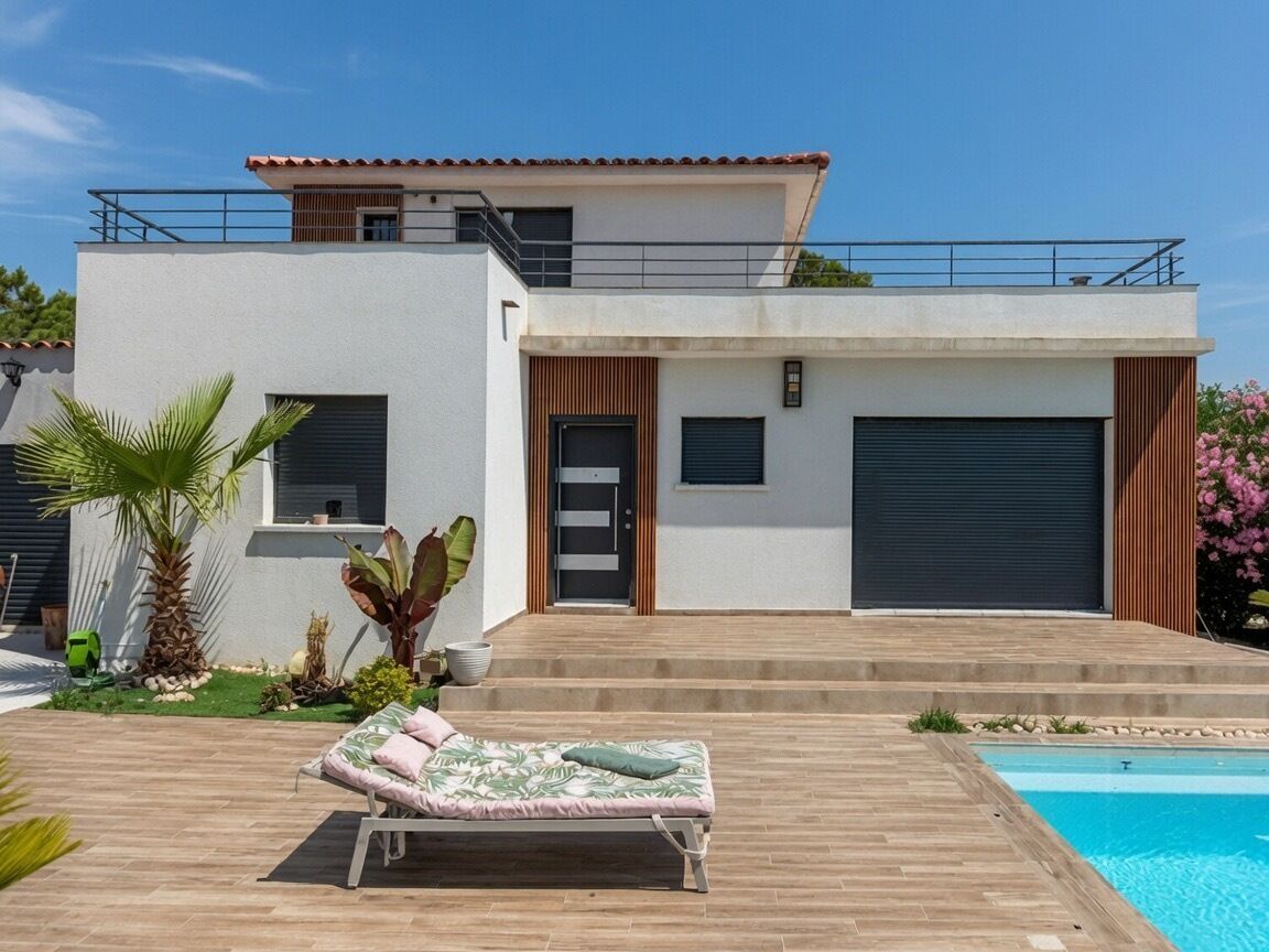A modern two-story house with a pool, a lounge chair, and a garden.