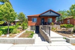 A two-story house with a brick exterior, a front porch, and a small garden area. - Cozy Studio with King Bed & Pet-Friendly Stay in Reno (Reno)