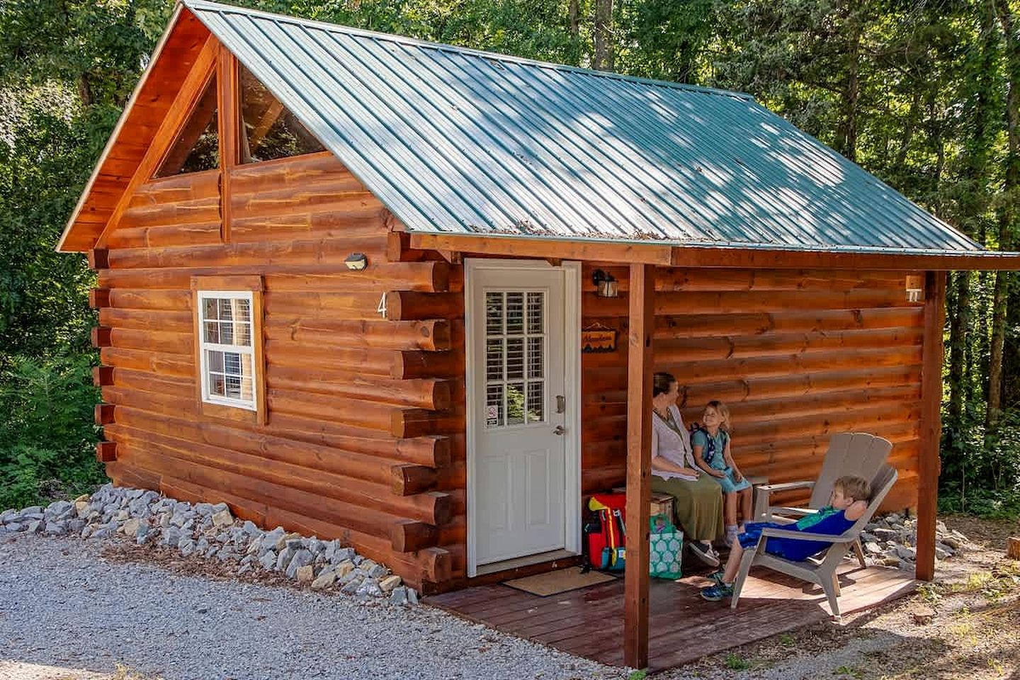 A log cabin with a porch, a door, and a window.