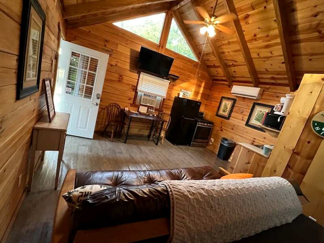 A log cabin with a loft bedroom, a dining area, and a kitchen.