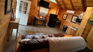 Eine Blockhütte mit Schlafzimmer im Zwischengeschoss, Essbereich und Küche.