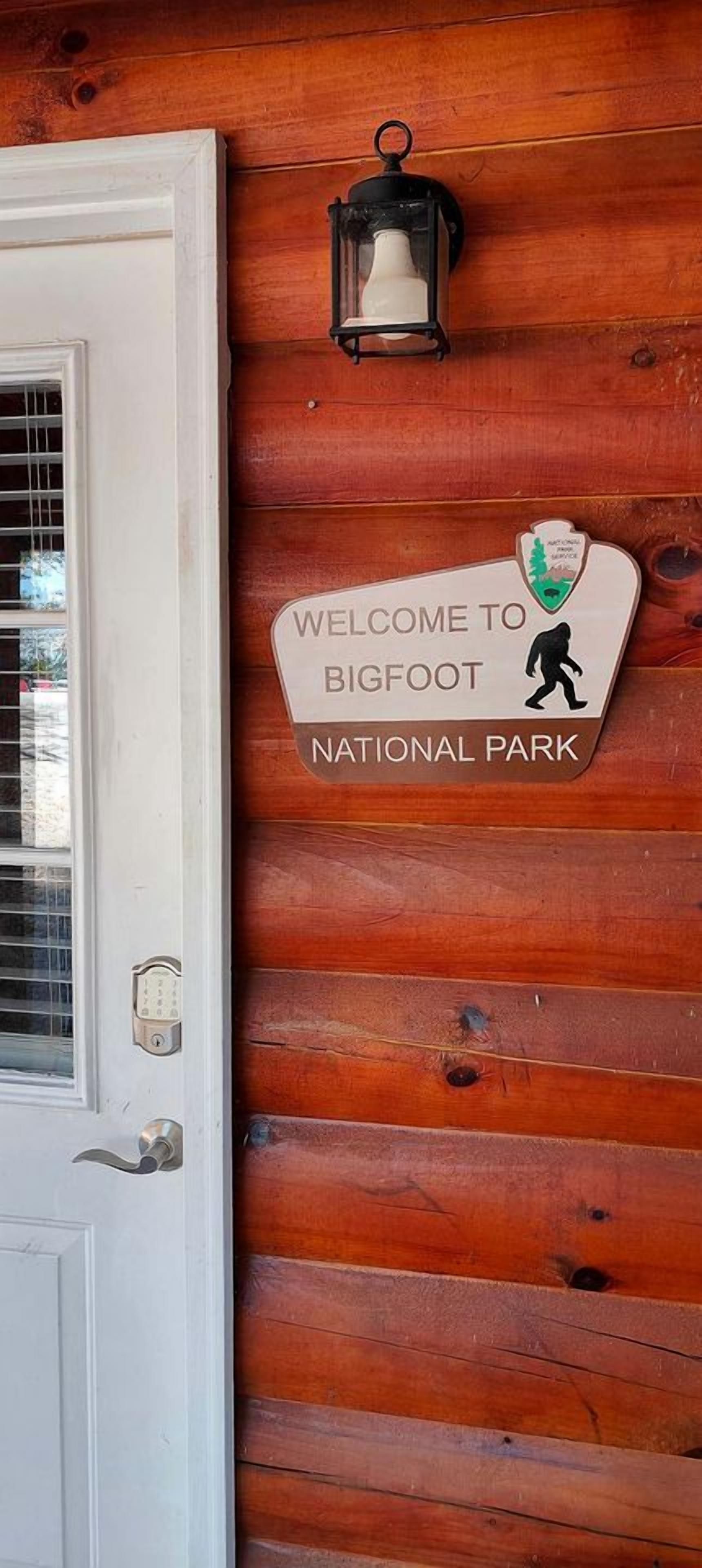 A wooden door with a welcome sign for Bigfoot National Park.