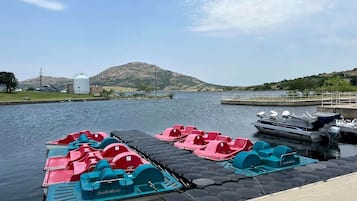 A dock with paddle boats and a boat named 'Lake of the Pines' in the background.