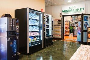 Ein S&G Minimarkt mit Getränkeautomaten und einer Auswahl an verpackten Waren.