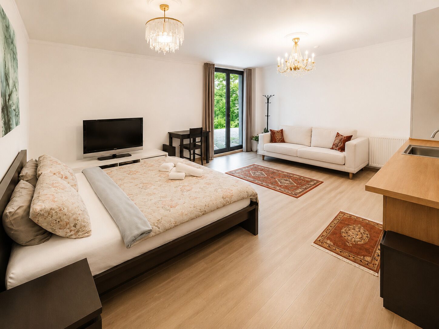 Ein Schlafzimmer mit Bett, Fernseher, Sofa und einem kleinen Tisch.