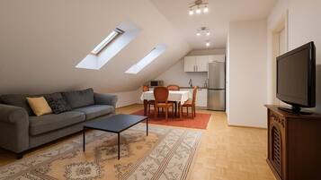 Un espacio habitable compacto con sofá, mesa de comedor y televisor.