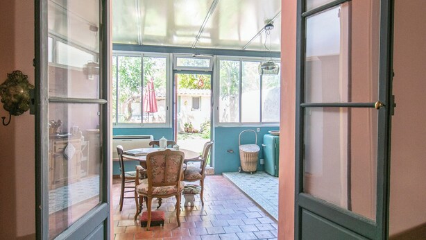 A hallway leading to a dining area with a table and chairs, a basket, and a door with glass panels. - Rare! Beautiful one-bedroom apartment with a garden in the heart of downtown Aix (Aix-en-Provence)