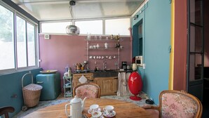 A dining area with a wooden table, chairs, and a kitchen in the background. - Rare! Beautiful one-bedroom apartment with a garden in the heart of downtown Aix (Aix-en-Provence)