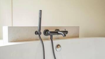 Une baignoire avec un robinet et une douchette à main.