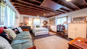 Una habitación acogedora con una cama, un sofá, un escritorio y un armario.