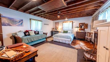 Um quarto com cama, sofá, escrivaninha e guarda-roupa.