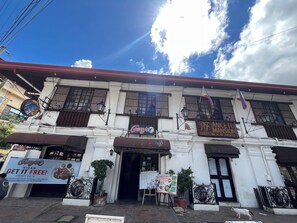 Un edificio con un letrero que anuncia Gerry's Vigan Crispy Pata, además de una posada y restaurante para turistas.