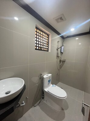 Un baño con inodoro, lavamanos y ducha.