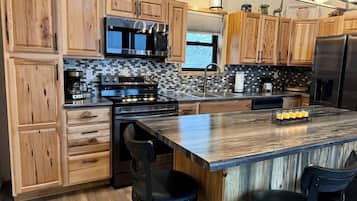 Une cuisine avec des meubles en bois, un grand îlot central et des appareils électroménagers modernes.