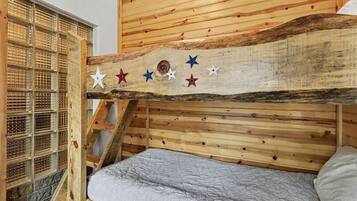 Una cama litera con cabecera de madera, una escalera y una pared con diseño de cuadrícula.