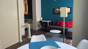 A modern living room with a sofa, a dining table, and a small white table.