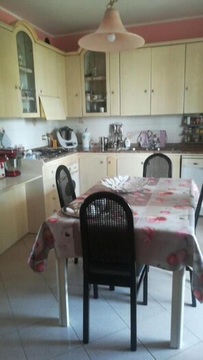 A kitchen with a dining table, chairs, and cabinets.