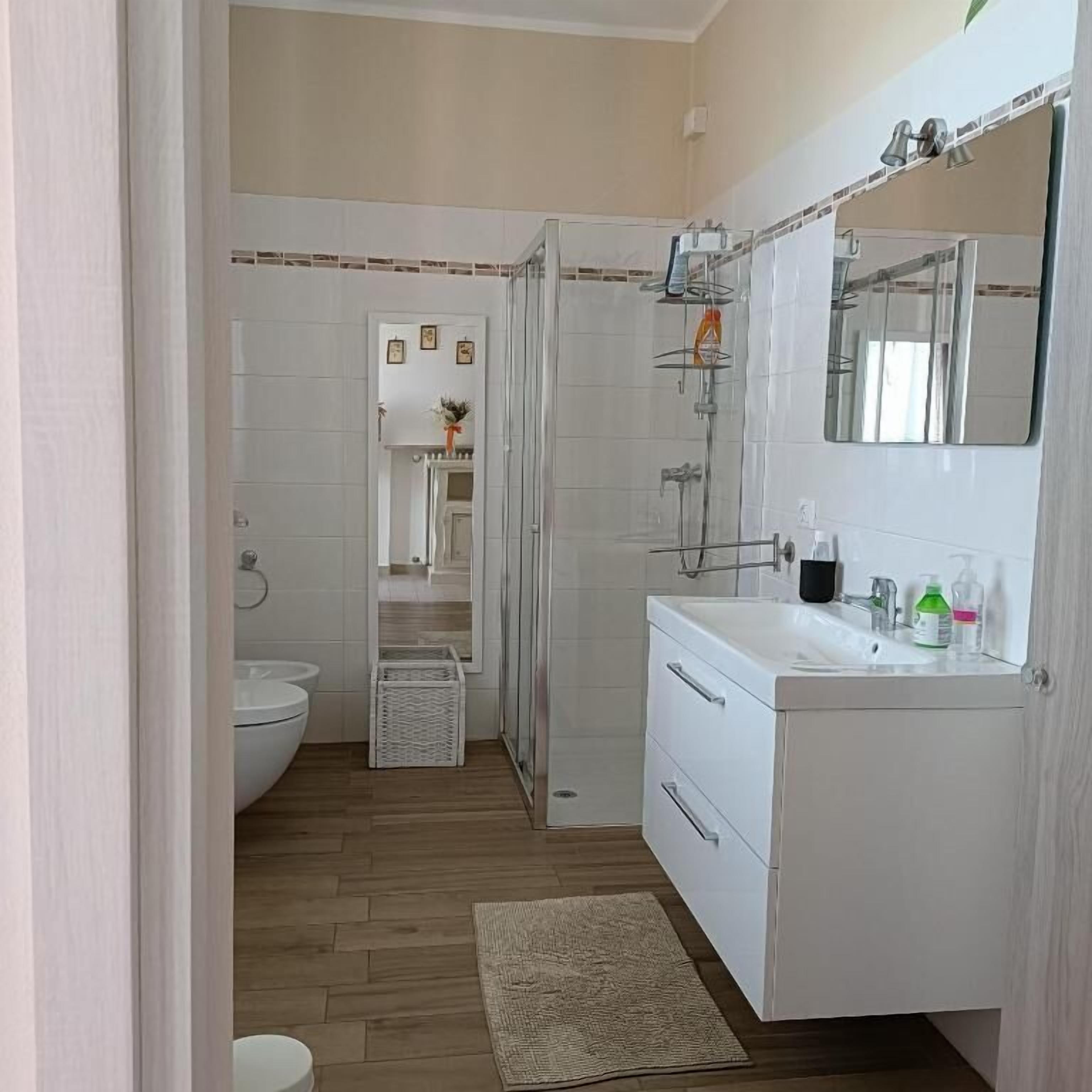 Une salle de bain avec douche, toilettes et lavabo.