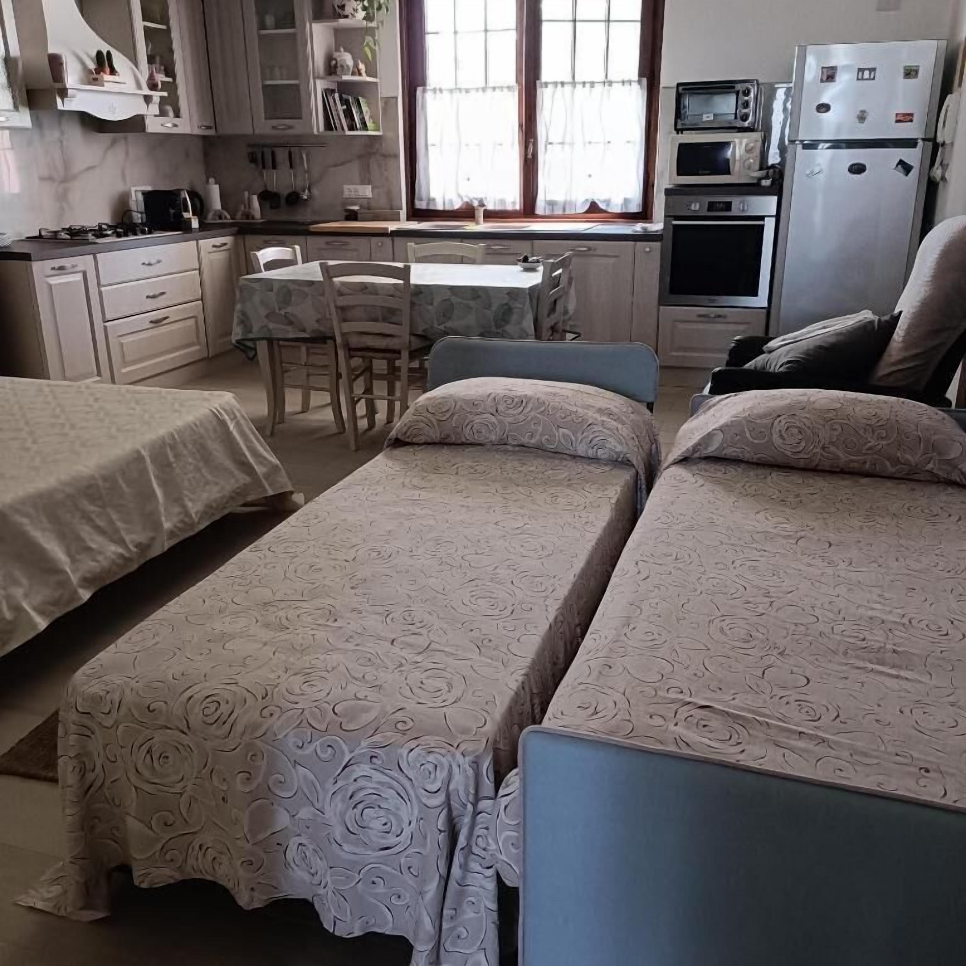 Ein Schlafzimmer mit zwei Betten, einem kleinen Tisch und einem Fenster.