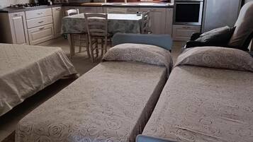Ein Schlafzimmer mit zwei Betten, einem kleinen Tisch und einem Fenster.