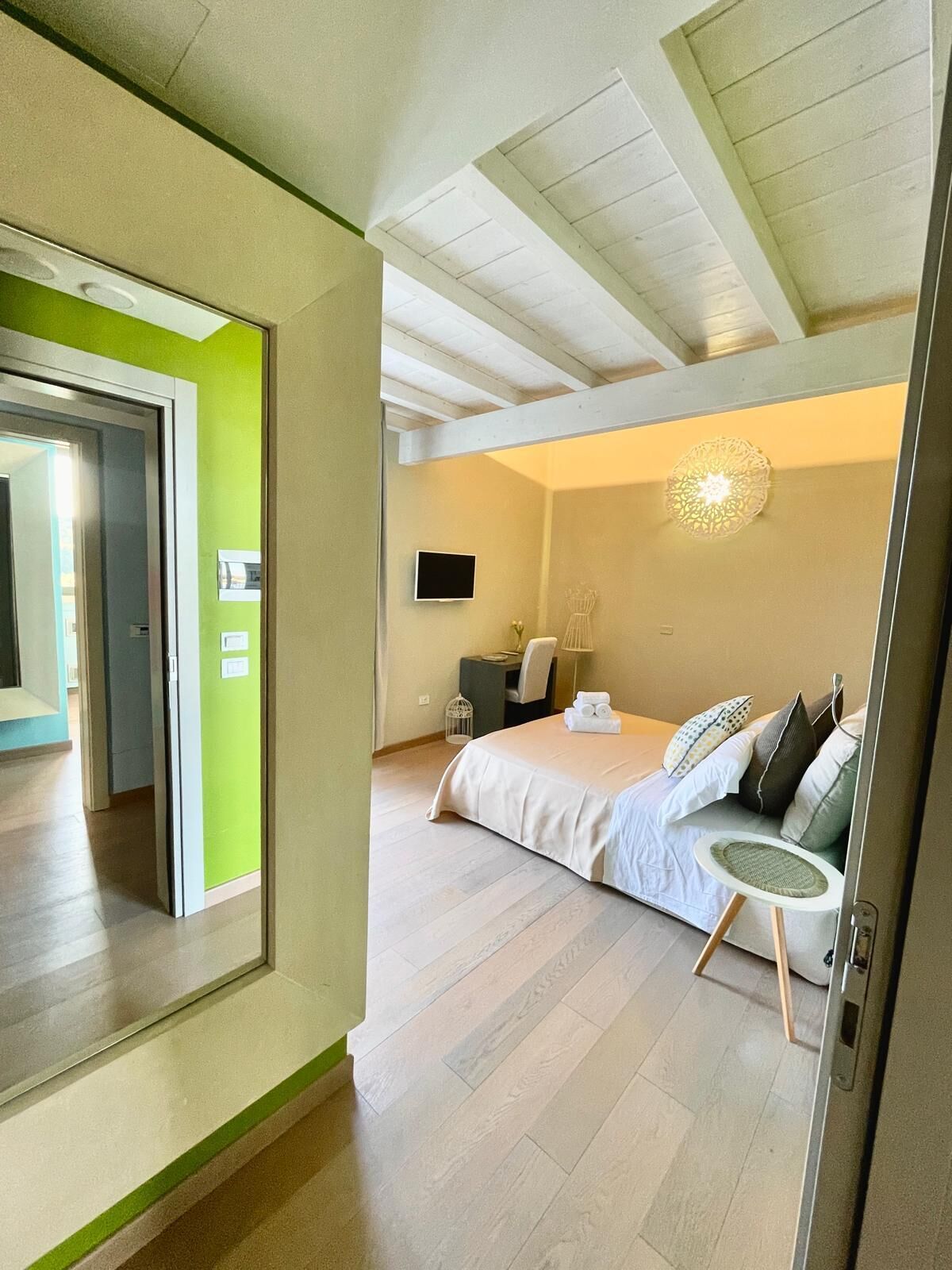 Una habitación de hotel moderna con cama, zona de estar y televisor.