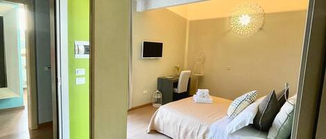 Una habitación de hotel moderna con cama, zona de estar y televisor.