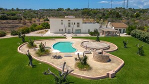 A modern house with a swimming pool, a patio area, and a well-maintained lawn. - Masseria Sant'Eleuterio (Collepasso)