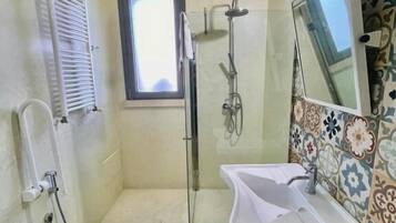 Une salle de bain équipée de toilettes, d’une douche, d’un lavabo et d’une fenêtre.