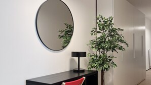 Een moderne werkruimte met een bureau, stoel, lamp, spiegel en een plant in pot.