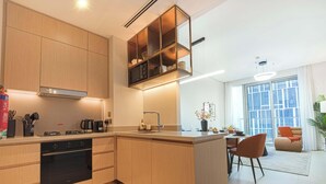 Een moderne keuken met houten kastjes, een ingebouwde magnetron en een gasfornuis.