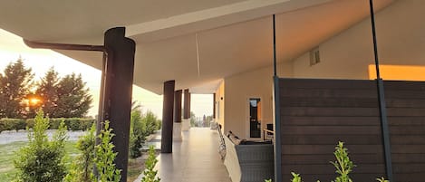 A covered outdoor area with a pathway, seating, and a view of the outdoors.