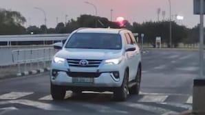 A white car with a red light on top, driving on a road. - Room-yoxall Overnight Stays (Durban)