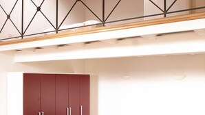 Ein Zimmer mit einem Bett, einem Kleiderschrank, einem Glastisch und einer Treppe.