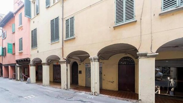 A row of buildings with arched doorways and a street in front. - Spiritosa - casa della zia (Bologna)