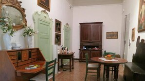 A dining area with a wooden table and chairs, a cabinet, and a mirror on the wall. - Spiritosa - casa della zia (Bologna)