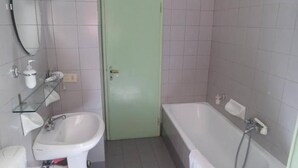 A bathroom with a toilet, sink, and bathtub. - Spiritosa - casa della zia (Bologna)