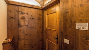 Una porta in legno con maniglia, una serratura e una piccola griglia di aerazione.
