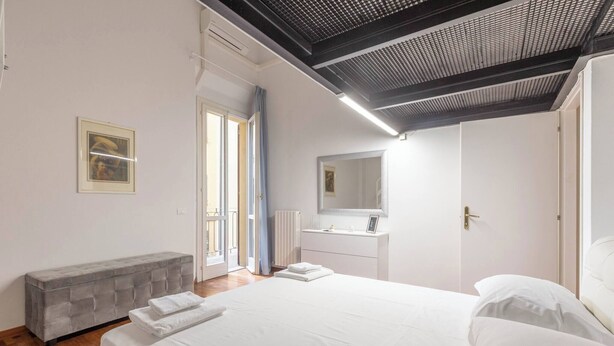 Une chambre à coucher avec un lit, un banc, une porte et une fenêtre.