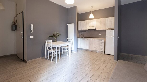 A modern apartment with a dining area, kitchen, and a small balcony. - Mascarella (Bologna)