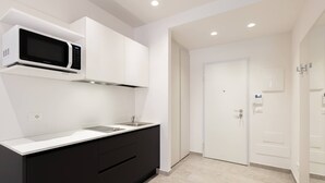 Eine moderne Küche mit Einbau-Mikrowelle, Spüle und dunklen Schränken.