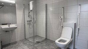 Un baño moderno con ducha, inodoro, lavabo y espejo.