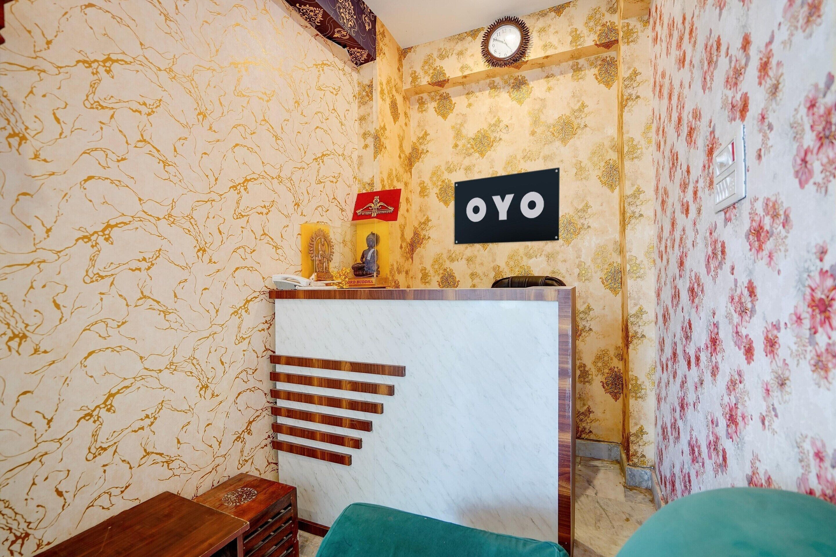 Une pièce comprenant un comptoir d’accueil, une horloge et un panneau indiquant « OYO ».